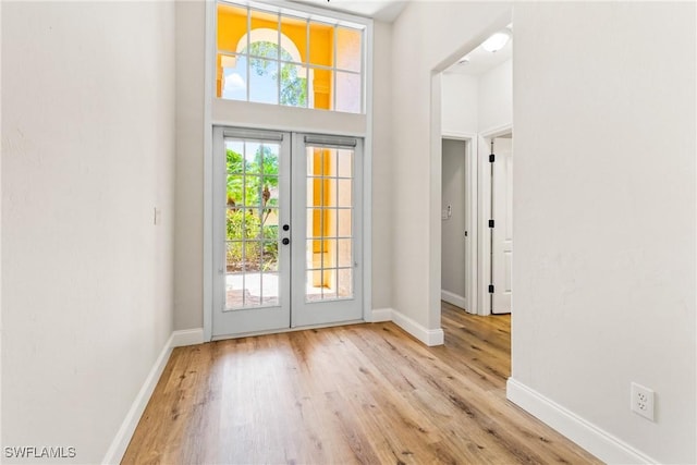 3519 Heron Cove Ct, Bonita Springs, FL 34134 - entryway featuring french doors, baseboards, a high ceiling, and wood finished floors
