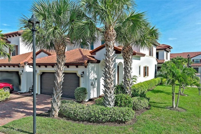9440 Sardinia Way Unit 110, Fort Myers, FL 33908 - view of front of home with an attached garage, stucco siding, decorative driveway, a front lawn, and a tiled roof