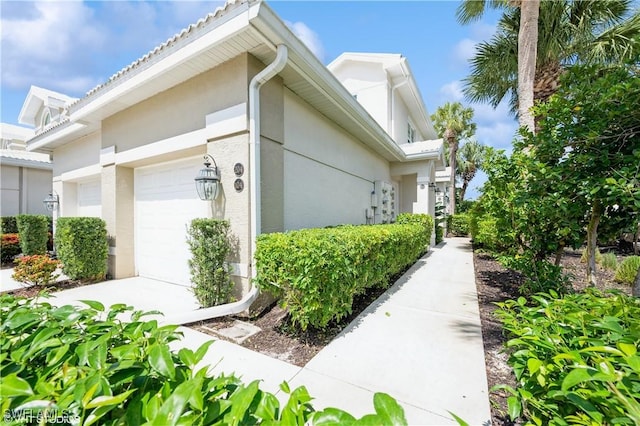 4610 Hawks Nest Dr Unit A104, Naples, FL 34114 - view of property exterior featuring stucco siding and a garage