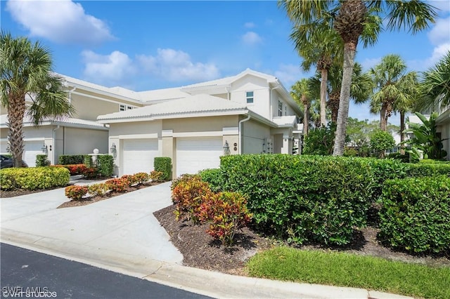 4610 Hawks Nest Dr Unit A104, Naples, FL 34114 - view of front of house featuring a garage, stucco siding, and concrete driveway