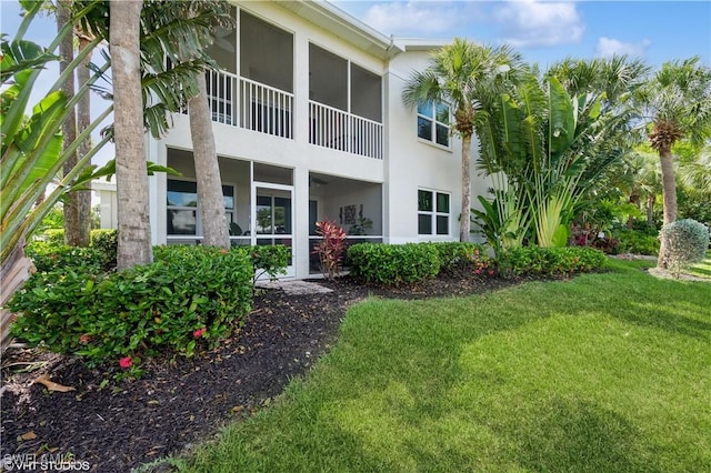 4610 Hawks Nest Dr Unit A104, Naples, FL 34114 - rear view of house with stucco siding, a lawn, and a sunroom