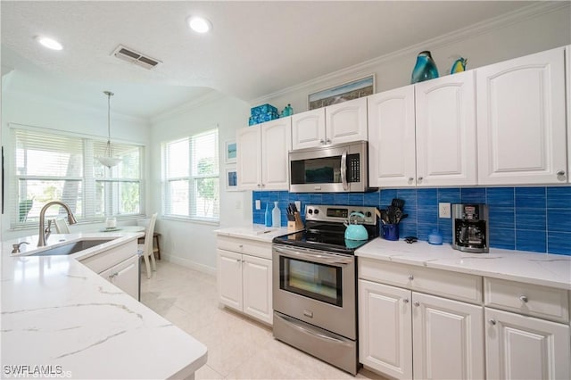 4610 Hawks Nest Dr Unit A104, Naples, FL 34114 - kitchen featuring appliances with stainless steel finishes, a sink, crown molding, white cabinetry, and light stone countertops