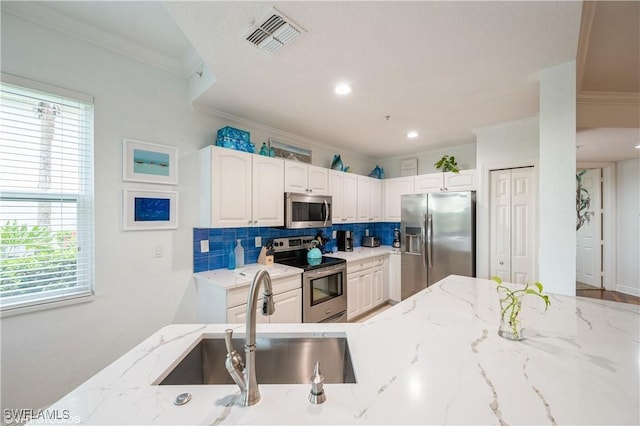 4610 Hawks Nest Dr Unit A104, Naples, FL 34114 - kitchen with appliances with stainless steel finishes, crown molding, a sink, backsplash, and light stone counters