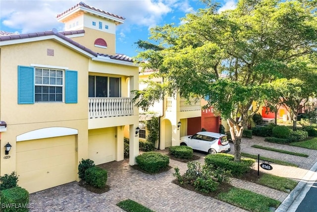 8565 Via Garibaldi Cir Unit 104, Estero, FL 33928 - townhome / multi-family property featuring a garage, stucco siding, and driveway