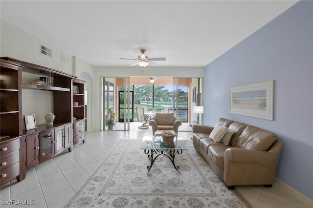 8565 Via Garibaldi Cir Unit 104, Estero, FL 33928 - living area with light tile patterned floors, a ceiling fan, and baseboards