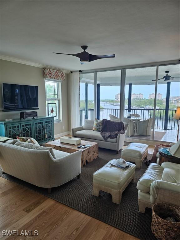 430 Cove Tower Dr Unit 501, Naples, FL 34110 - living area featuring ceiling fan, wood finished floors, ornamental molding, and a water view