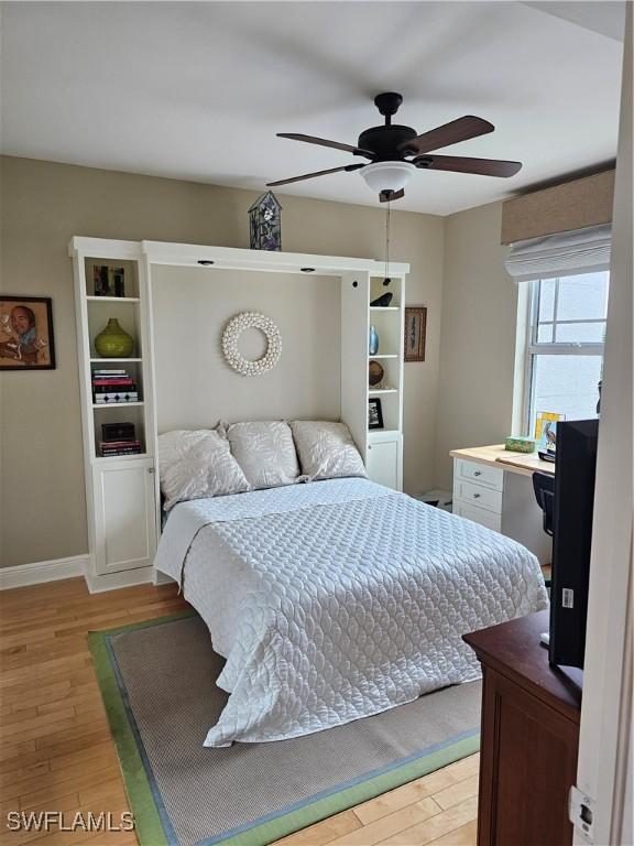 430 Cove Tower Dr Unit 501, Naples, FL 34110 - bedroom featuring light wood-style floors, a ceiling fan, and baseboards