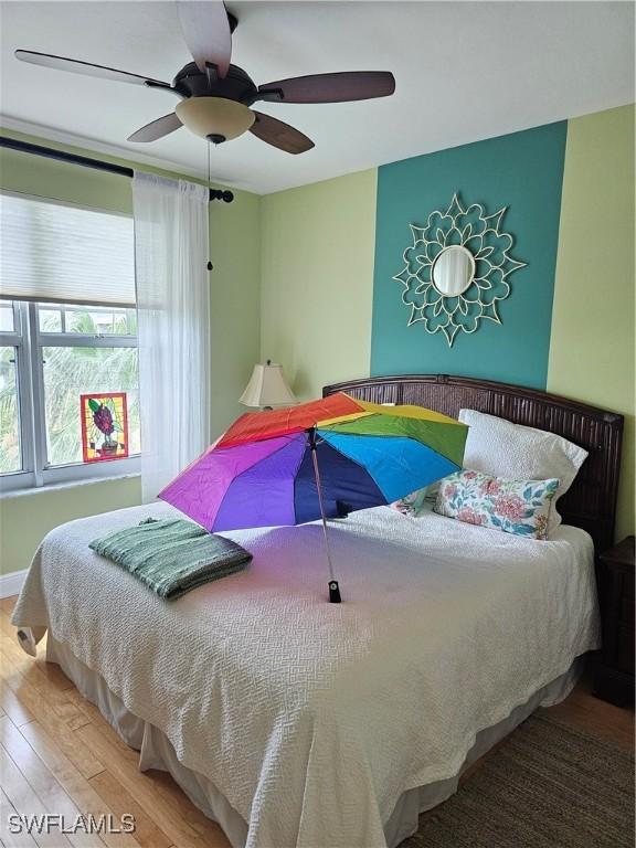 430 Cove Tower Dr Unit 501, Naples, FL 34110 - bedroom with wood finished floors and ceiling fan