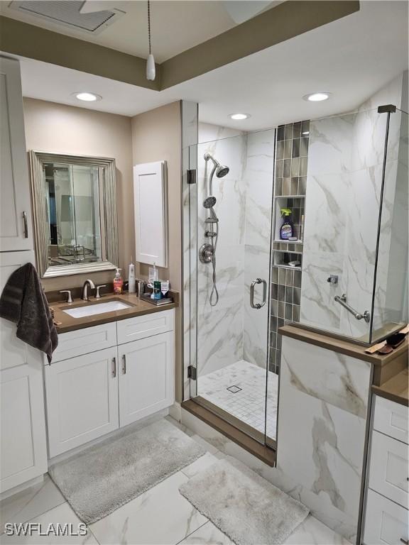430 Cove Tower Dr Unit 501, Naples, FL 34110 - bathroom featuring vanity, a marble finish shower, recessed lighting, and marble finish floors