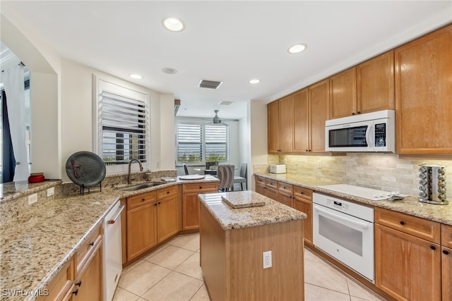 11600 Court Of Palms Unit 201, Fort Myers, FL 33908 - kitchen with white appliances, a sink, a center island, light tile patterned floors, and light stone counters