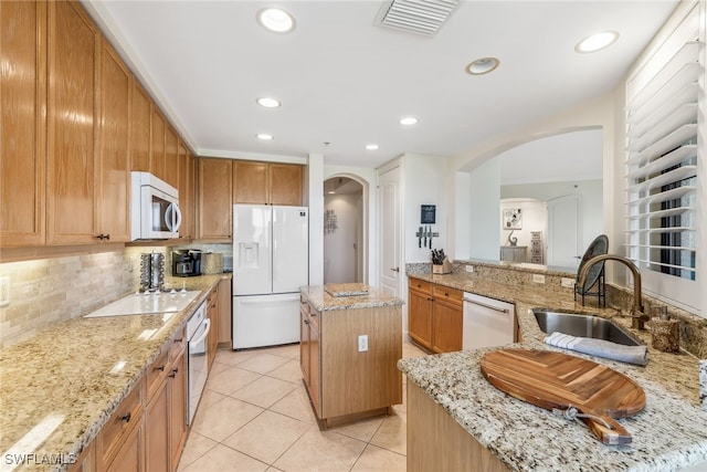 11600 Court Of Palms Unit 201, Fort Myers, FL 33908 - kitchen with white appliances, arched walkways, a sink, backsplash, and light tile patterned flooring