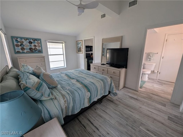 11250 Porpoise Point Rd Unit 8, Matlacha, FL 33993 - bedroom with vaulted ceiling, light wood finished floors, ceiling fan, baseboards, and ensuite bath