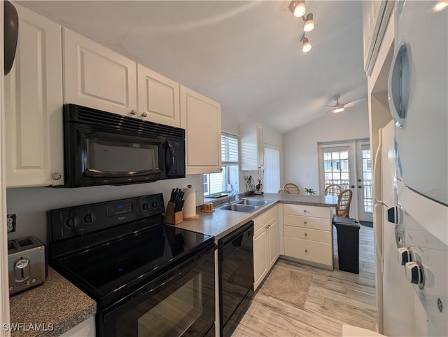 11250 Porpoise Point Rd Unit 8, Matlacha, FL 33993 - kitchen featuring black appliances, a sink, white cabinetry, a peninsula, and vaulted ceiling
