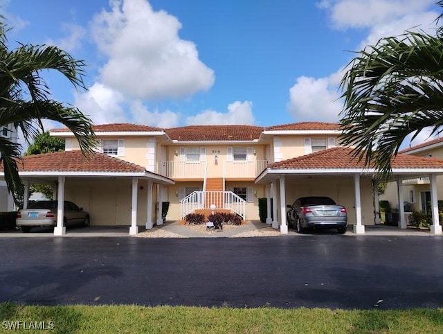 5116 Coronado Pkwy Unit 16, Cape Coral, FL 33904 - view of front of property featuring an attached carport, asphalt driveway, stucco siding, a tile roof, and stairway