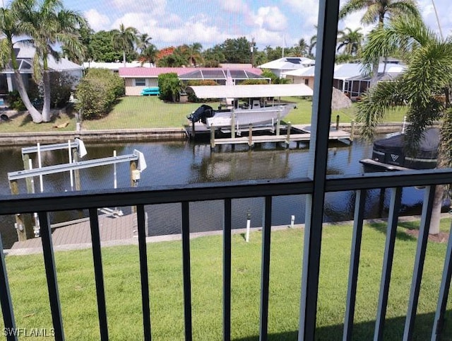 5116 Coronado Pkwy Unit 16, Cape Coral, FL 33904 - dock with boat lift, a water view, and a yard