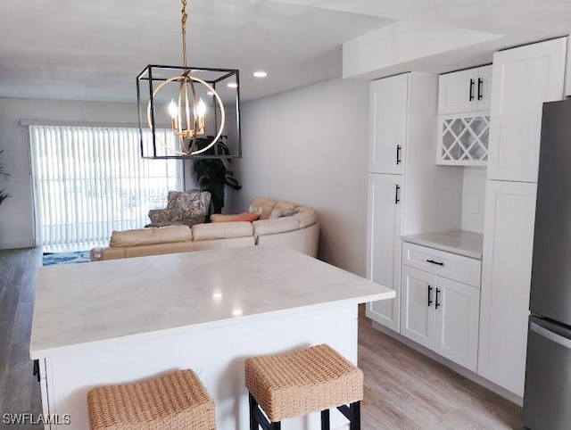 5116 Coronado Pkwy Unit 16, Cape Coral, FL 33904 - kitchen with freestanding refrigerator, light wood-style flooring, a chandelier, white cabinetry, and recessed lighting
