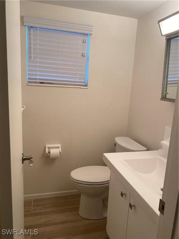 1516 Tropic Ter Unit 1516, North Fort Myers, FL 33903 - bathroom featuring wood finished floors, vanity, toilet, and baseboards