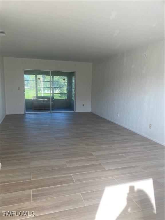 1516 Tropic Ter Unit 1516, North Fort Myers, FL 33903 - spare room featuring baseboards and wood finish floors