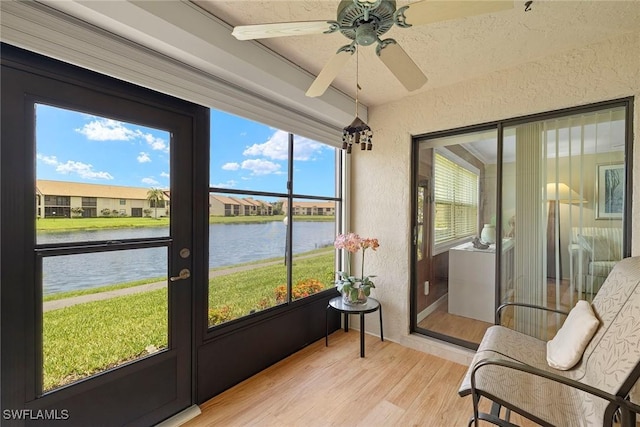 8411 Charter Club Cir Unit 1, Fort Myers, FL 33919 - sunroom featuring a water view, wood finished floors, a textured wall, and a ceiling fan