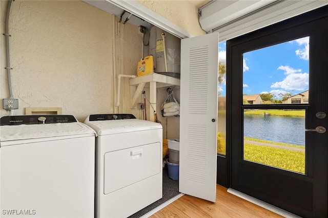 8411 Charter Club Cir Unit 1, Fort Myers, FL 33919 - laundry area with washing machine and clothes dryer, plenty of natural light, light wood finished floors, a textured wall, and a water view