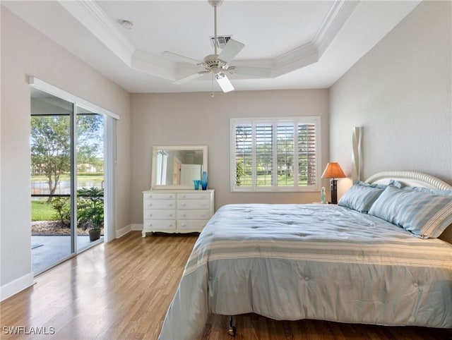 10230 Cobble Hill Rd, Bonita Springs, FL 34135 - bedroom with crown molding, a tray ceiling, access to exterior, multiple windows, and wood finished floors