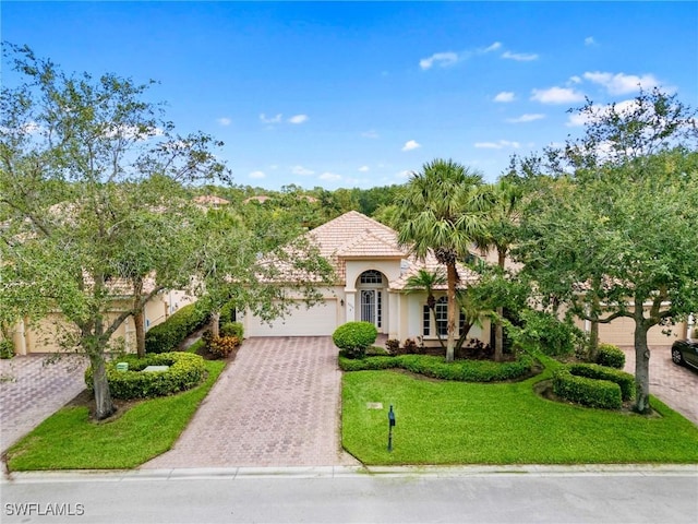 10230 Cobble Hill Rd, Bonita Springs, FL 34135 - mediterranean / spanish-style home with an attached garage, stucco siding, driveway, a front yard, and a tile roof