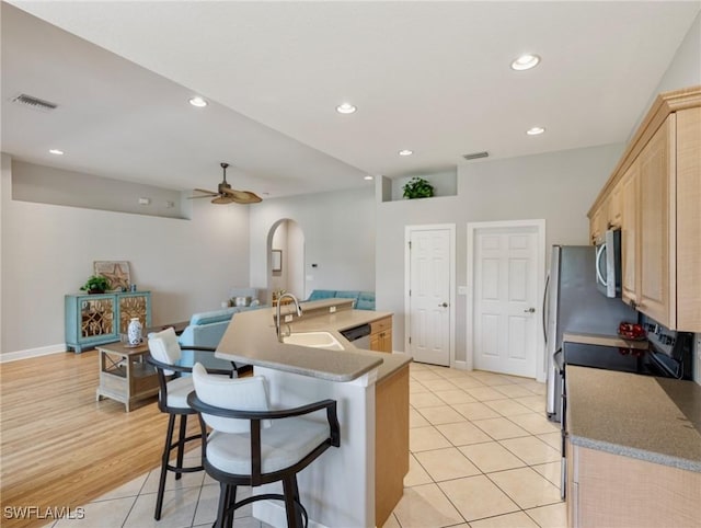 10230 Cobble Hill Rd, Bonita Springs, FL 34135 - kitchen with a sink, light brown cabinets, a kitchen breakfast bar, ceiling fan, and appliances with stainless steel finishes