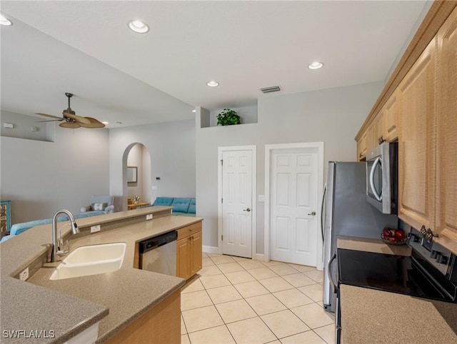 10230 Cobble Hill Rd, Bonita Springs, FL 34135 - kitchen featuring stainless steel appliances, a sink, arched walkways, light brown cabinetry, and a ceiling fan