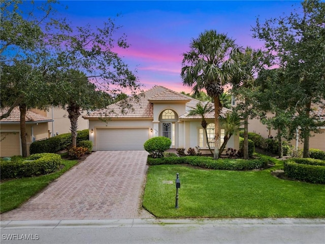 10230 Cobble Hill Rd, Bonita Springs, FL 34135 - mediterranean / spanish home featuring an attached garage, stucco siding, driveway, a yard, and a tile roof