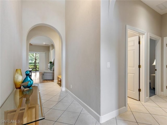 10230 Cobble Hill Rd, Bonita Springs, FL 34135 - hallway featuring light tile patterned flooring, arched walkways, and baseboards