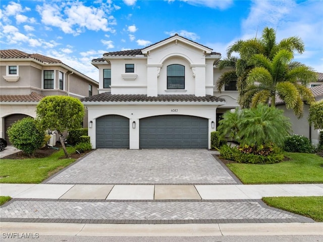 4083 Aspen Chase Dr, Naples, FL 34119 - mediterranean / spanish-style house featuring stucco siding, a garage, decorative driveway, and a tile roof