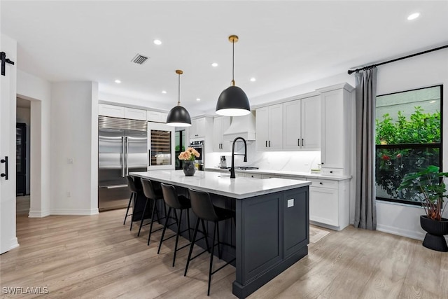 4083 Aspen Chase Dr, Naples, FL 34119 - kitchen with stainless steel built in refrigerator, a spacious island, light wood-style flooring, recessed lighting, and baseboards