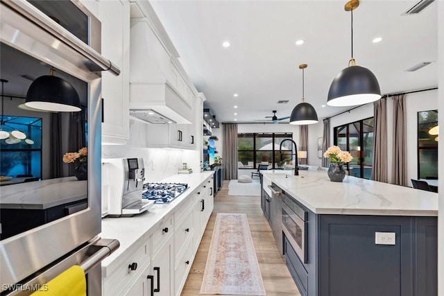 4083 Aspen Chase Dr, Naples, FL 34119 - kitchen featuring appliances with stainless steel finishes, recessed lighting, white cabinets, custom range hood, and a spacious island