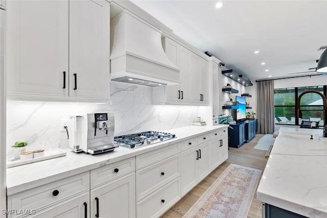 4083 Aspen Chase Dr, Naples, FL 34119 - kitchen featuring custom range hood, stainless steel gas stovetop, white cabinetry, light wood-type flooring, and recessed lighting