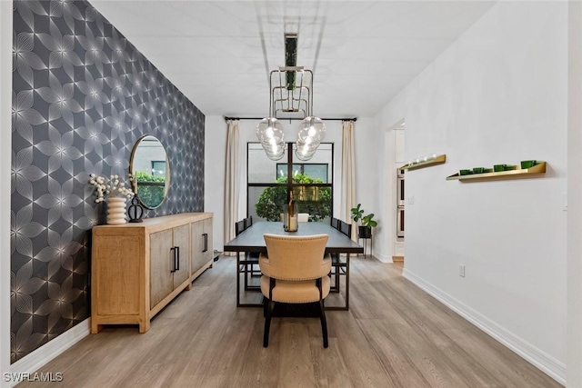 4083 Aspen Chase Dr, Naples, FL 34119 - dining room featuring an accent wall, a chandelier, light wood-type flooring, and baseboards