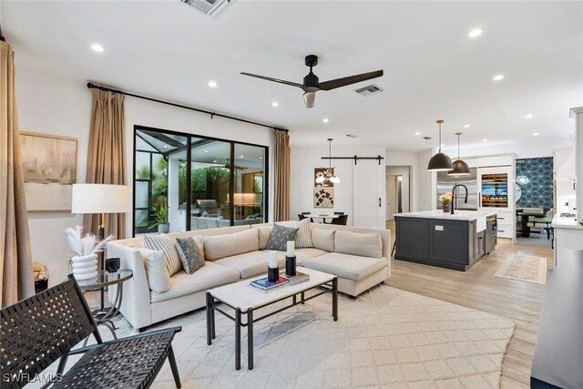 4083 Aspen Chase Dr, Naples, FL 34119 - living area with recessed lighting, light wood-style floors, ceiling fan, and a barn door