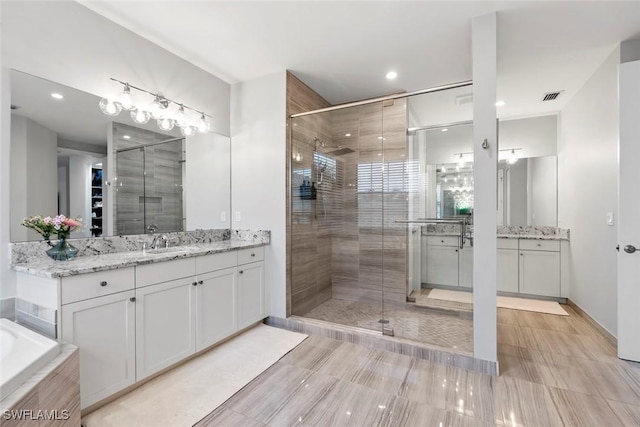 4083 Aspen Chase Dr, Naples, FL 34119 - bathroom with a stall shower, two vanities, a tub, and recessed lighting