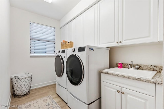 4083 Aspen Chase Dr, Naples, FL 34119 - laundry area with washer and dryer, cabinet space, light wood finished floors, and baseboards
