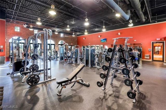 11923 Adoncia Way Unit 2802, Fort Myers, FL 33912 - exercise room with brick wall and a towering ceiling