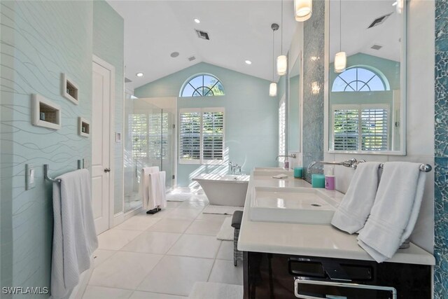 687 9th Ave S, Naples, FL 34102 - full bathroom with lofted ceiling, a freestanding tub, double vanity, a stall shower, and tile patterned floors