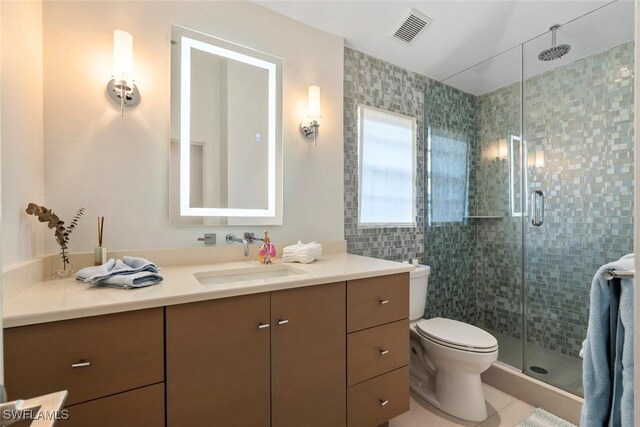 687 9th Ave S, Naples, FL 34102 - full bathroom with vanity, toilet, a shower stall, tile patterned flooring, and tile walls