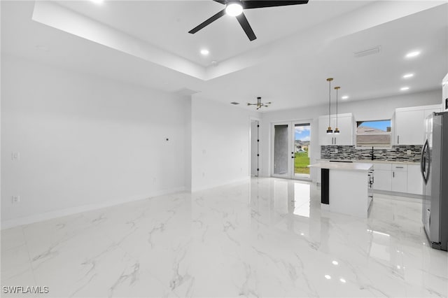 2813 38th St SW, Lehigh Acres, FL 33976 - unfurnished living room with a sink, ceiling fan, baseboards, recessed lighting, and a tray ceiling