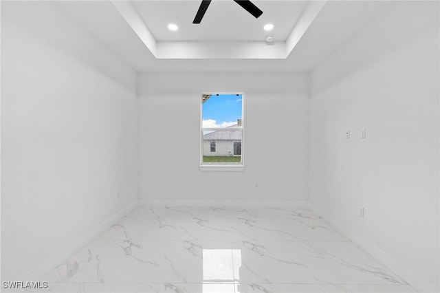 2813 38th St SW, Lehigh Acres, FL 33976 - unfurnished room with baseboards, ceiling fan, a raised ceiling, marble finish flooring, and recessed lighting