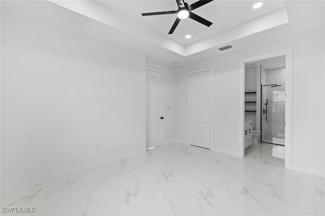 2813 38th St SW, Lehigh Acres, FL 33976 - unfurnished bedroom featuring baseboards, recessed lighting, marble finish floors, a tray ceiling, and ensuite bath