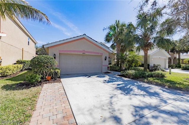 12860 Seaside Key Ct, North Fort Myers, FL 33903 - view of front of home with stucco siding, driveway, and an attached garage