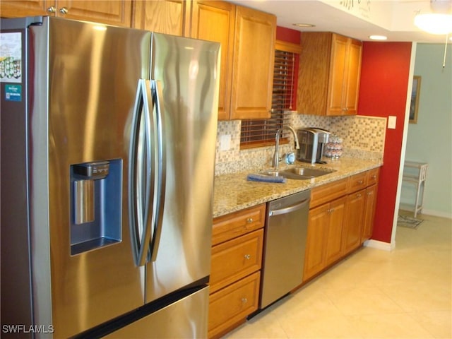 4802 Lakewood Blvd Unit B13, Naples, FL 34112 - kitchen featuring stainless steel appliances, a sink, decorative backsplash, light stone counters, and brown cabinets