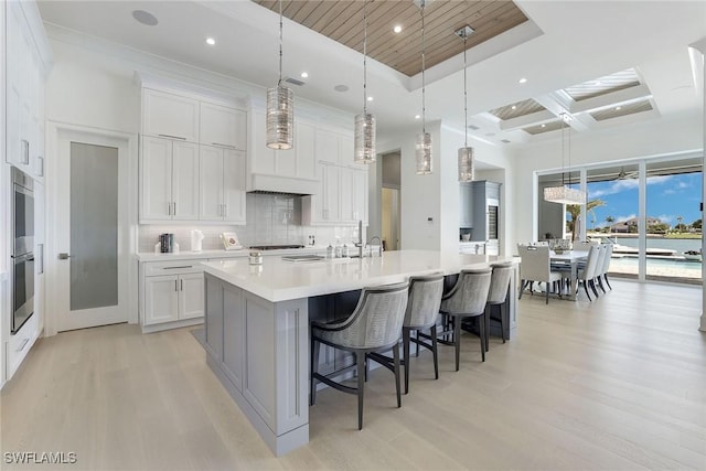 1761 Ludlow Rd, Marco Island, FL 34145 - kitchen with light wood-style flooring, a spacious island, tasteful backsplash, light countertops, and a towering ceiling