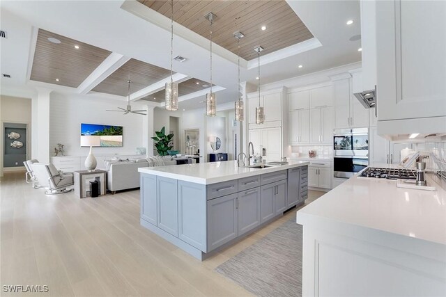 1761 Ludlow Rd, Marco Island, FL 34145 - kitchen with wooden ceiling with exposed beams, gray cabinets, light wood-style floors, light countertops, and a raised ceiling