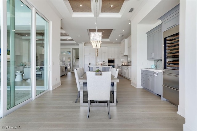 1761 Ludlow Rd, Marco Island, FL 34145 - dining space with a tray ceiling, a chandelier, light wood-style floors, recessed lighting, and ornamental molding