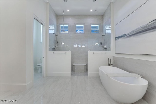1761 Ludlow Rd, Marco Island, FL 34145 - bathroom featuring a walk in shower, a soaking tub, toilet, and tile walls
